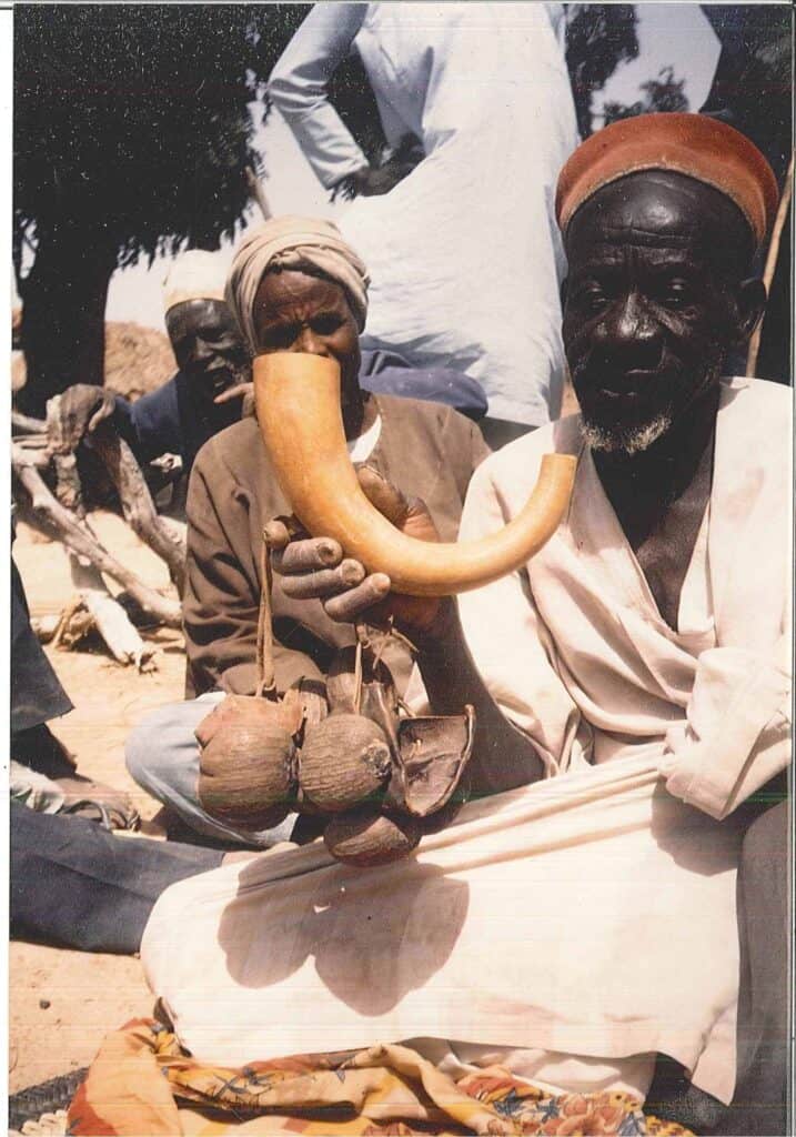 Der Shuwa Arab-Musiker Hassan Wa'al Jime hält das Instrument Al-buq in der Hand