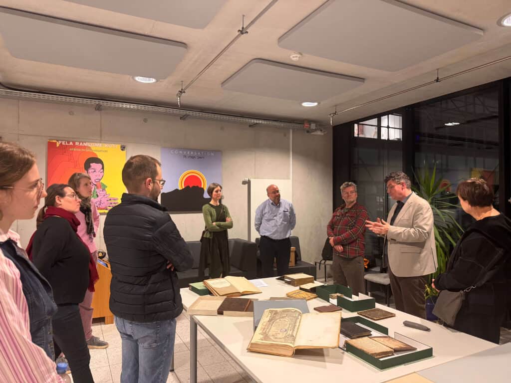 Jüdische Manuskripte auf einem Tisch, umringt von Menschengruppe